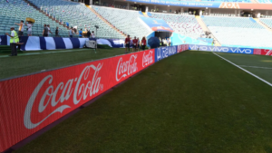 Biển quảng cáo LED của Coca-Cola được lắp đặt dọc đường pitch trong sân vận động, giúp thương hiệu nổi bật trước khán giả theo dõi trực tiếp và qua truyền hình.